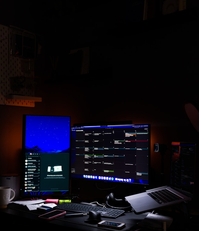 A desk with two monitors and a laptop, set up for remote work